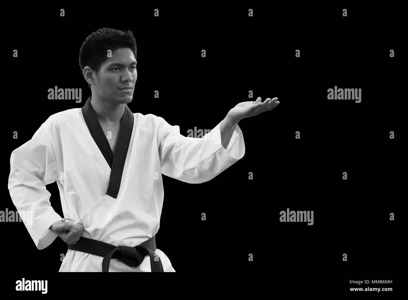 Master Black belt Taekwondo Fighter Stand for Ridgehand Outward Block or Sonnal deung bakkat makgi posture on black. Stock Photo