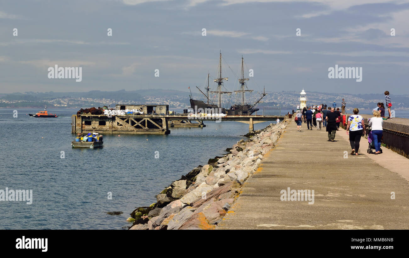 El Galeon Andalucia passing the old fuel jetty and breakwater at Brixham in Devon after being escorted into open water by the returning pilot boat. Stock Photo