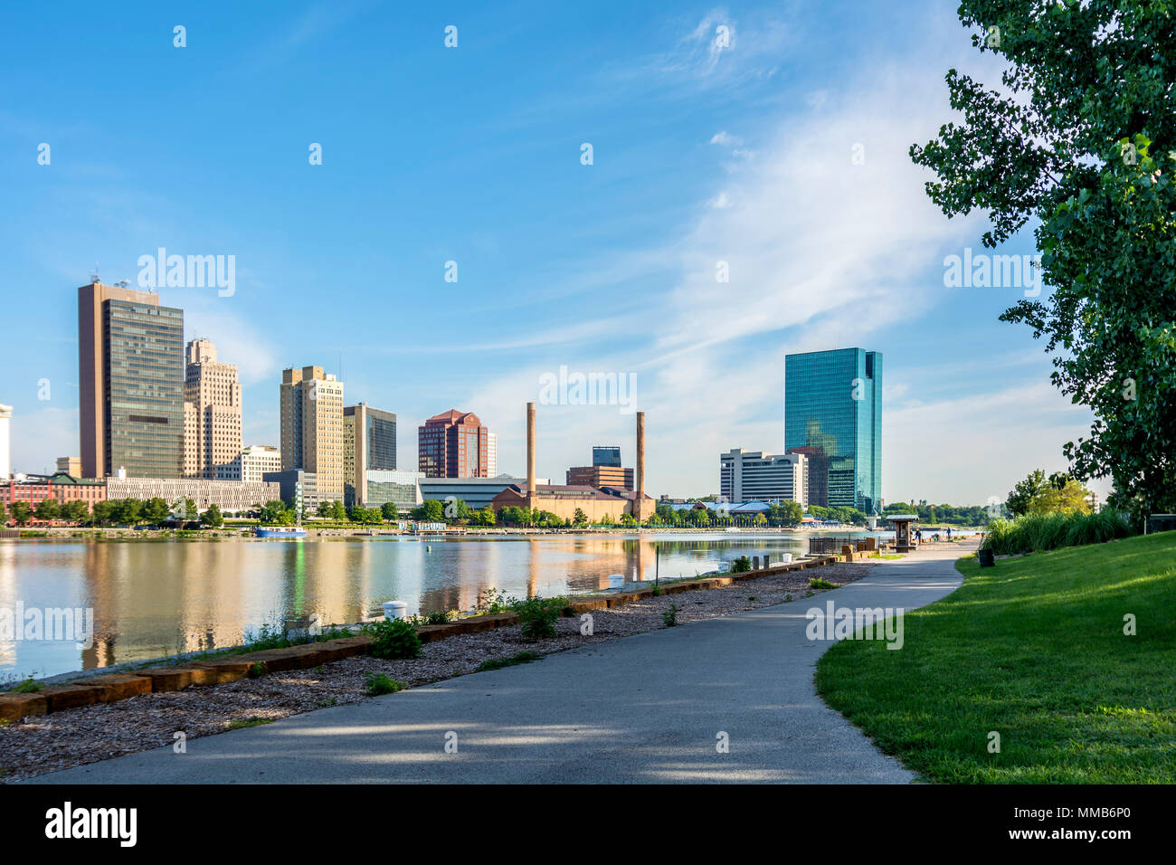 A panoramic view of downtown Toledo Ohio's skyline from across the Maumee River at a popular local park.  A beautiful blue sky with white clouds. Stock Photo