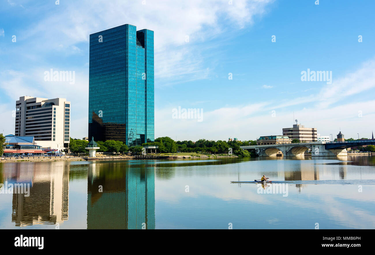 A panoramic view of downtown Toledo Ohio's skyline reflecting into the Maumee River a with a man rowing on the water.  A beautiful  blue sky with whit Stock Photo