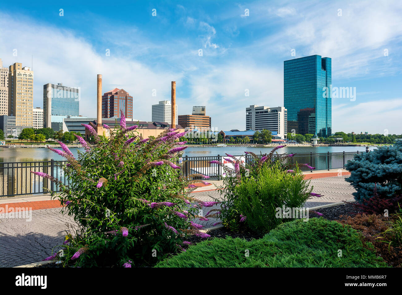 A panoramic view of downtown Toledo Ohio's skyline from across the Maumee River at the Docks.  A beautiful blue sky with white clouds for a backdrop. Stock Photo