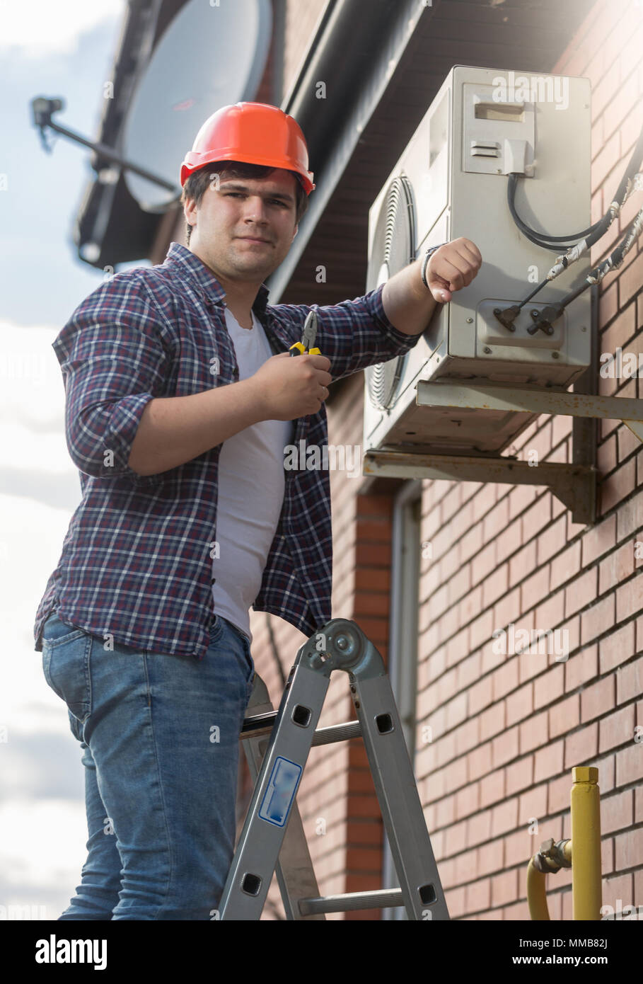 Portrait of young air conditioner engineer checking conditioning system