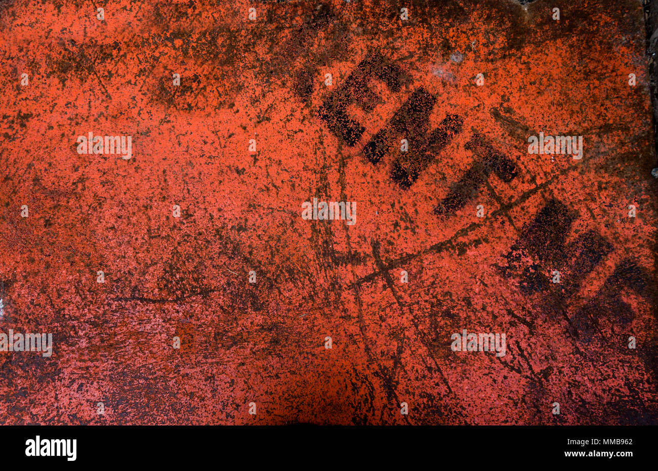Gritty bright red texture on a rusted metal with the words 'rent me' Stock Photo