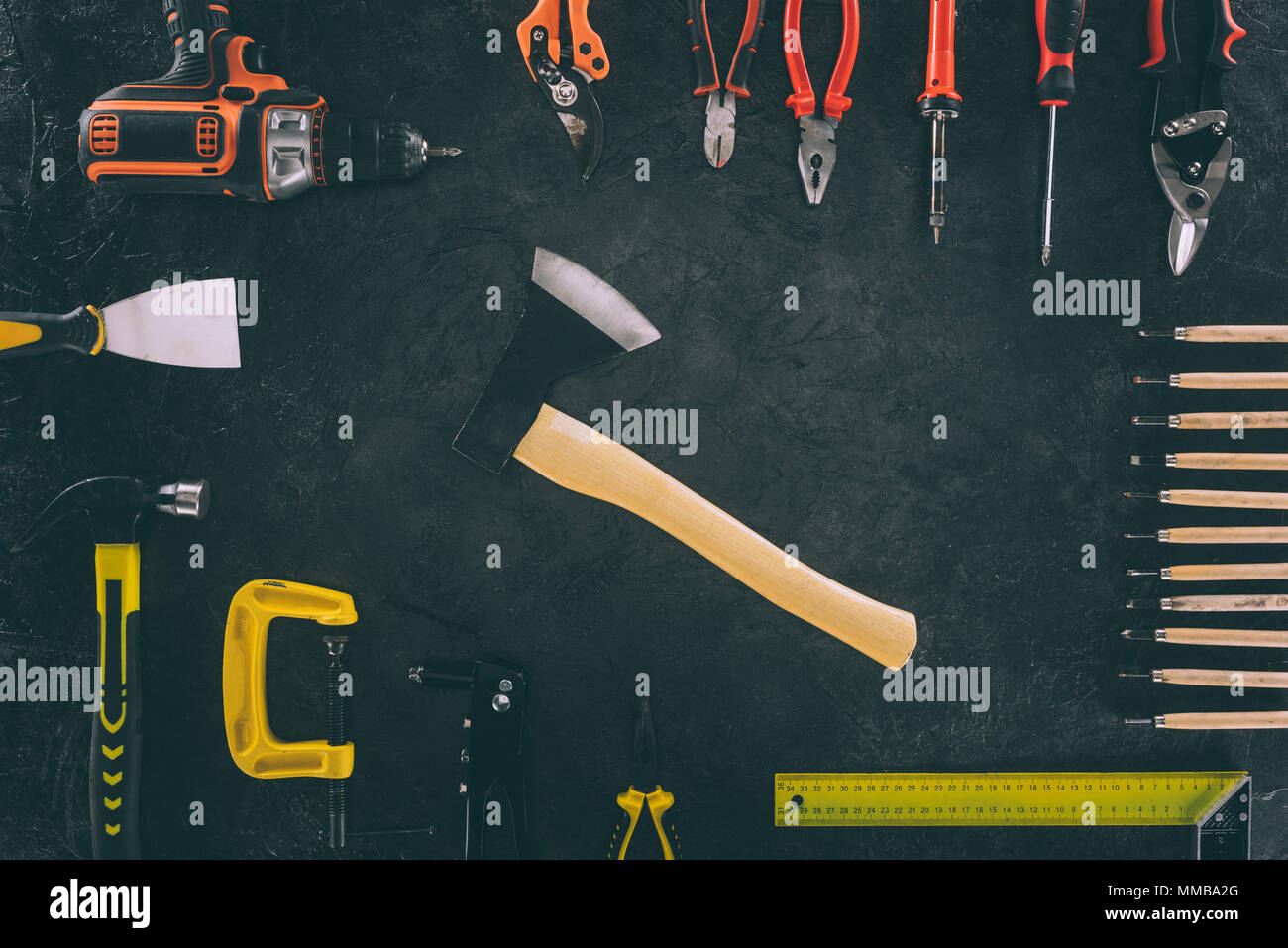 flat lay with axe and various arranged carpentry equipment on dark surface Stock Photo
