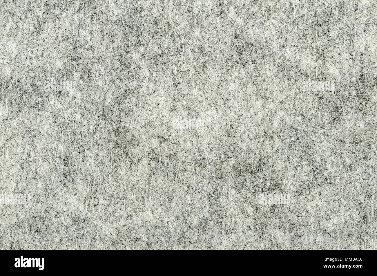Gray felt surface. Textile material, made of matted synthetic fibers. White, gray and black acrylic pressed together. Fabric pattern. Background. Stock Photo
