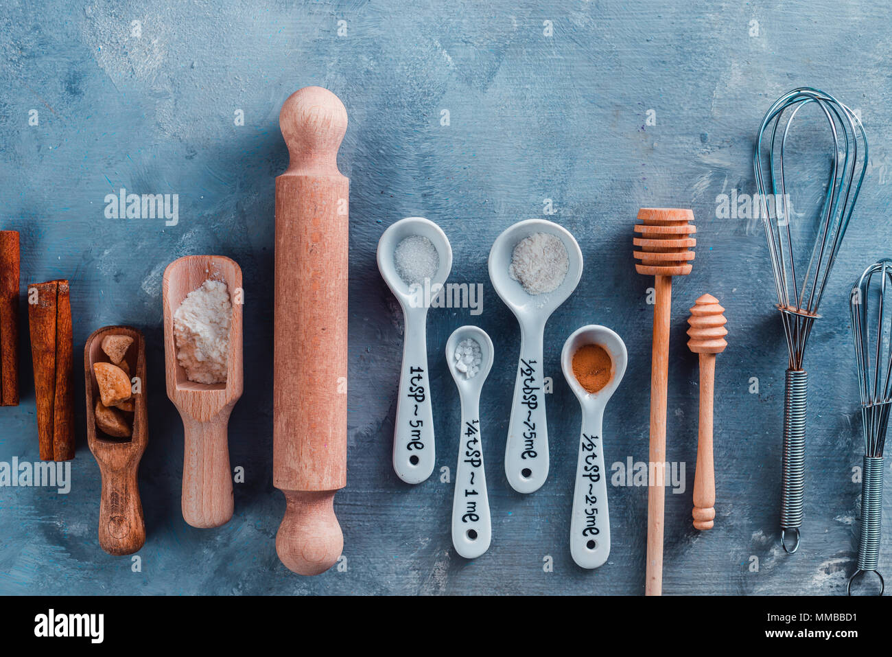 https://c8.alamy.com/comp/MMBBD1/kitchen-utensils-for-baking-rolling-pin-and-measuring-spoons-on-a-blue-table-with-copy-space-cooking-pastry-concept-MMBBD1.jpg