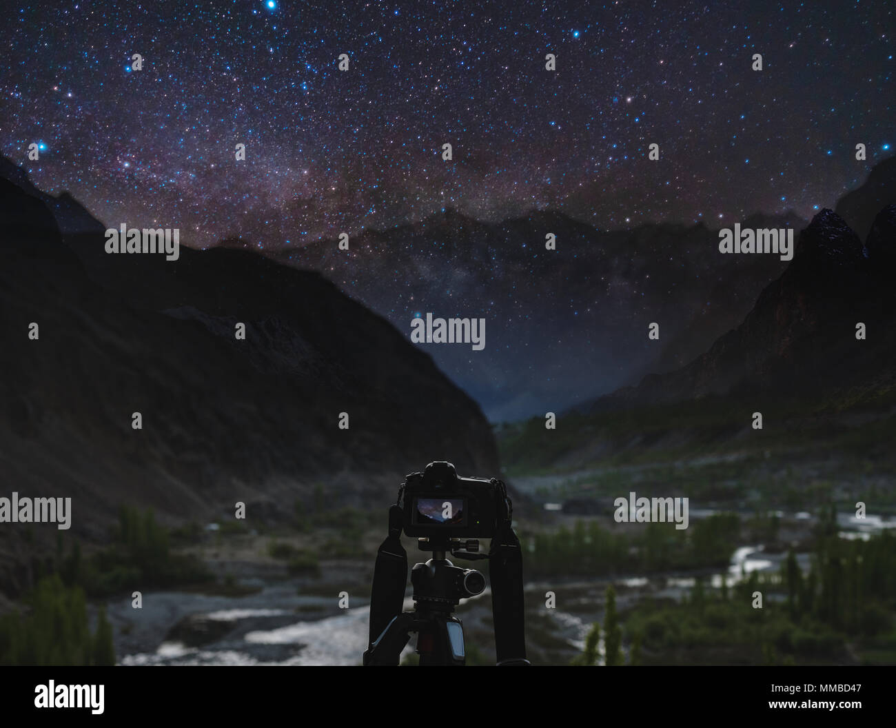 Taking night photography by dslr camera, Night sky full of stars and milky way with silhouette mountains valley Stock Photo
