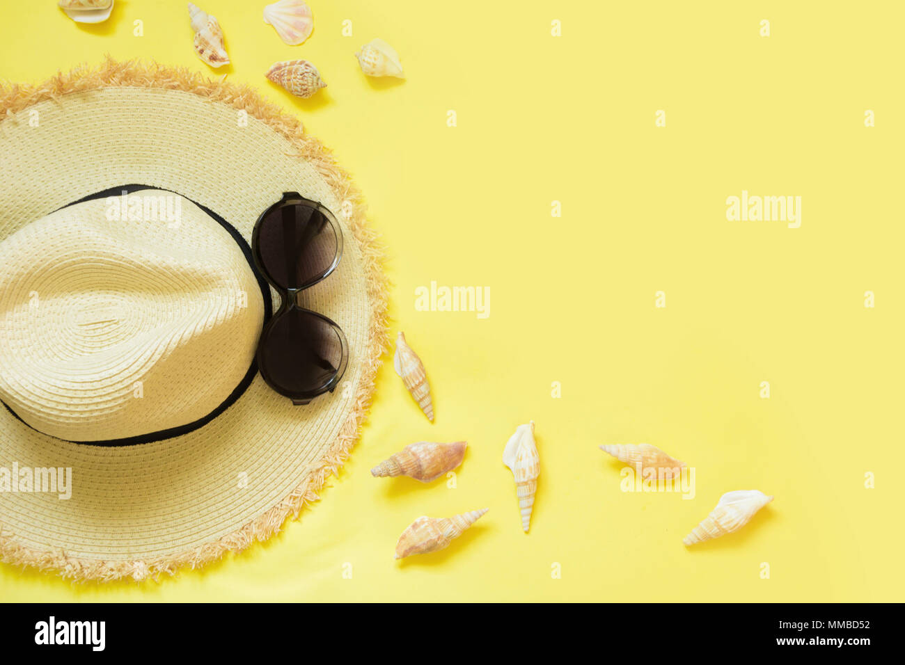 Straw beach foman's hat and black sun glasses with seashells on yellow ...
