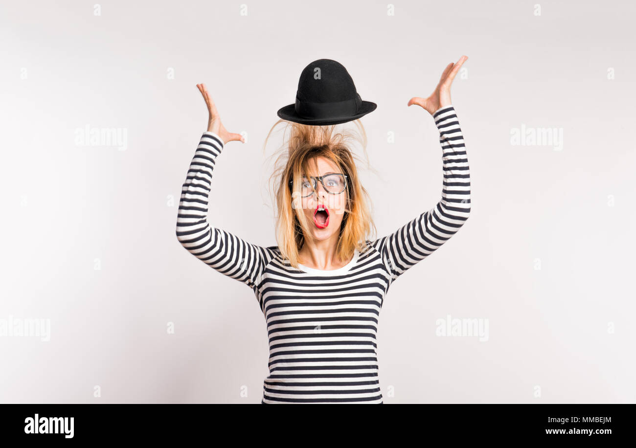 Portrait of a young beautiful woman in studio, throwing hat in the air