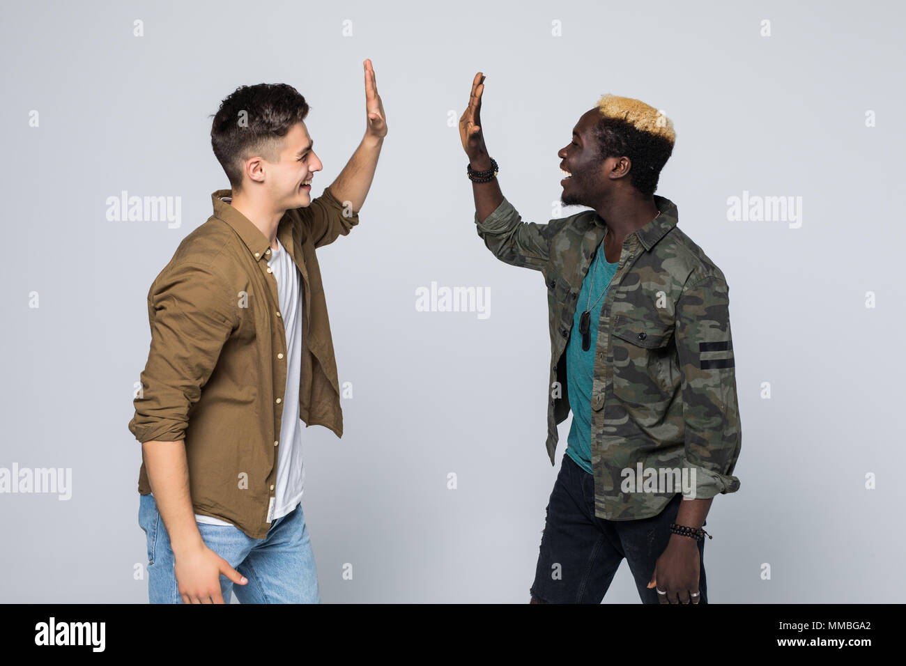 Portrait of an excited young mixed race friends giving high five over ...
