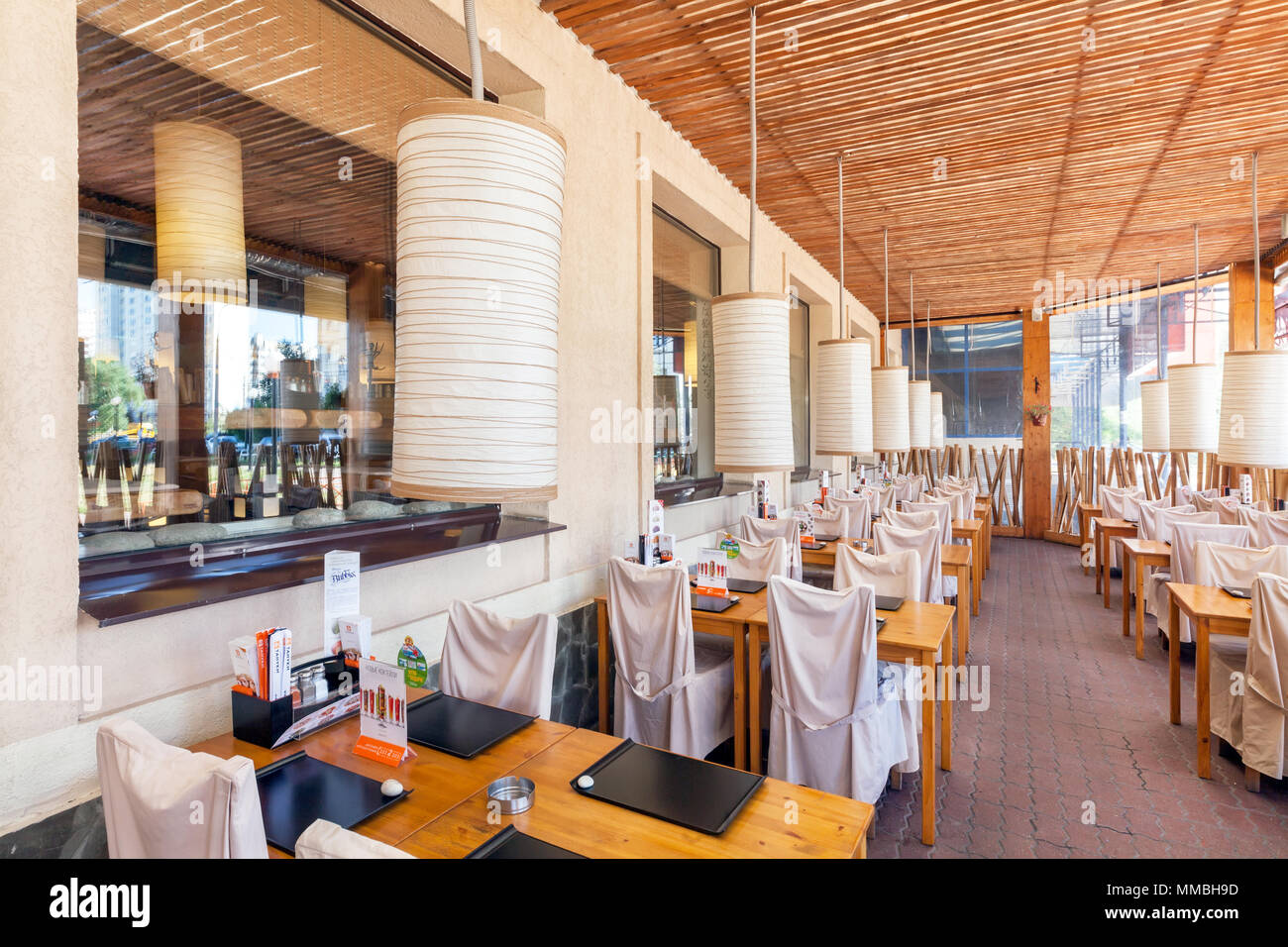 MOSCOW - AUGUST 2014: Interior of the Japanese sushi restaurant chain 'TANUKI'. Many tables on the closed summer veranda of the restaurant Stock Photo