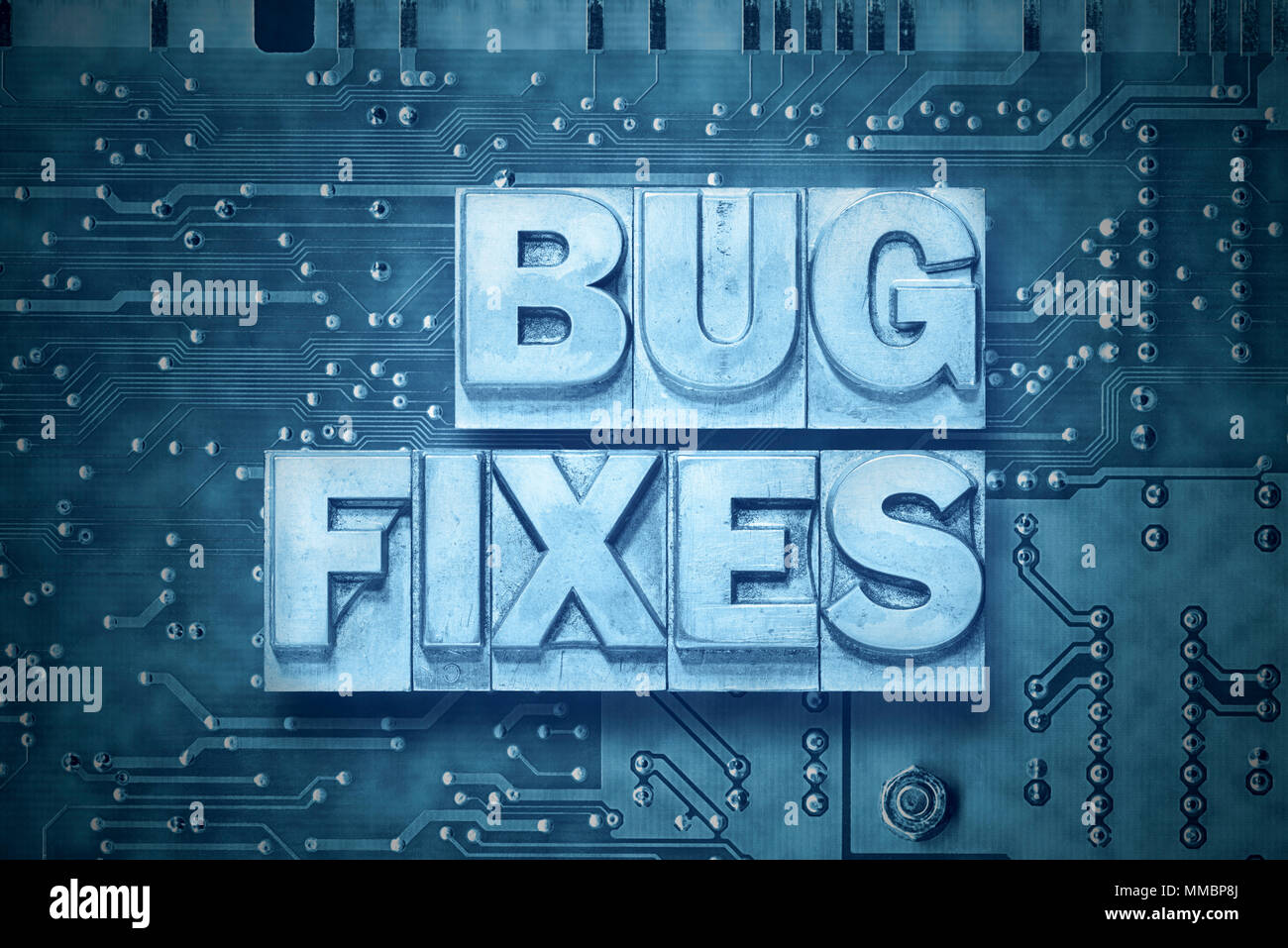 bug fixes phrase made from metallic letterpress blocks on pc board background Stock Photo