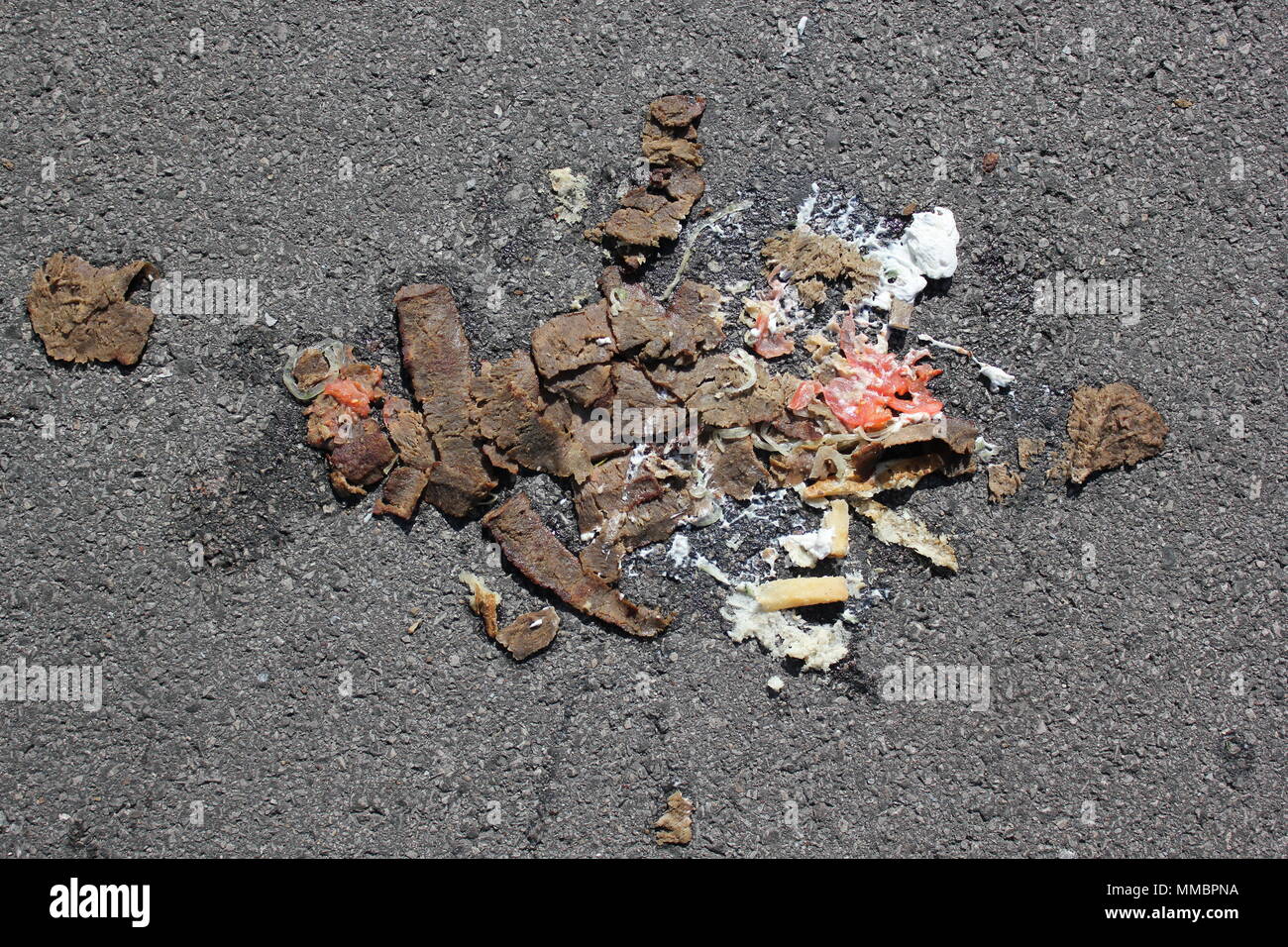 Greek gyro dropped on the street and run over by a car. Stock Photo