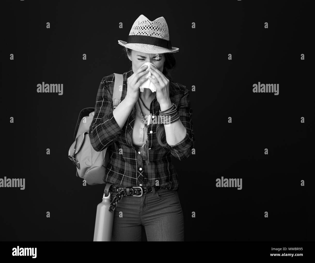Searching for inspiring places. ill traveller woman in a plaid shirt blowing nose against background Stock Photo