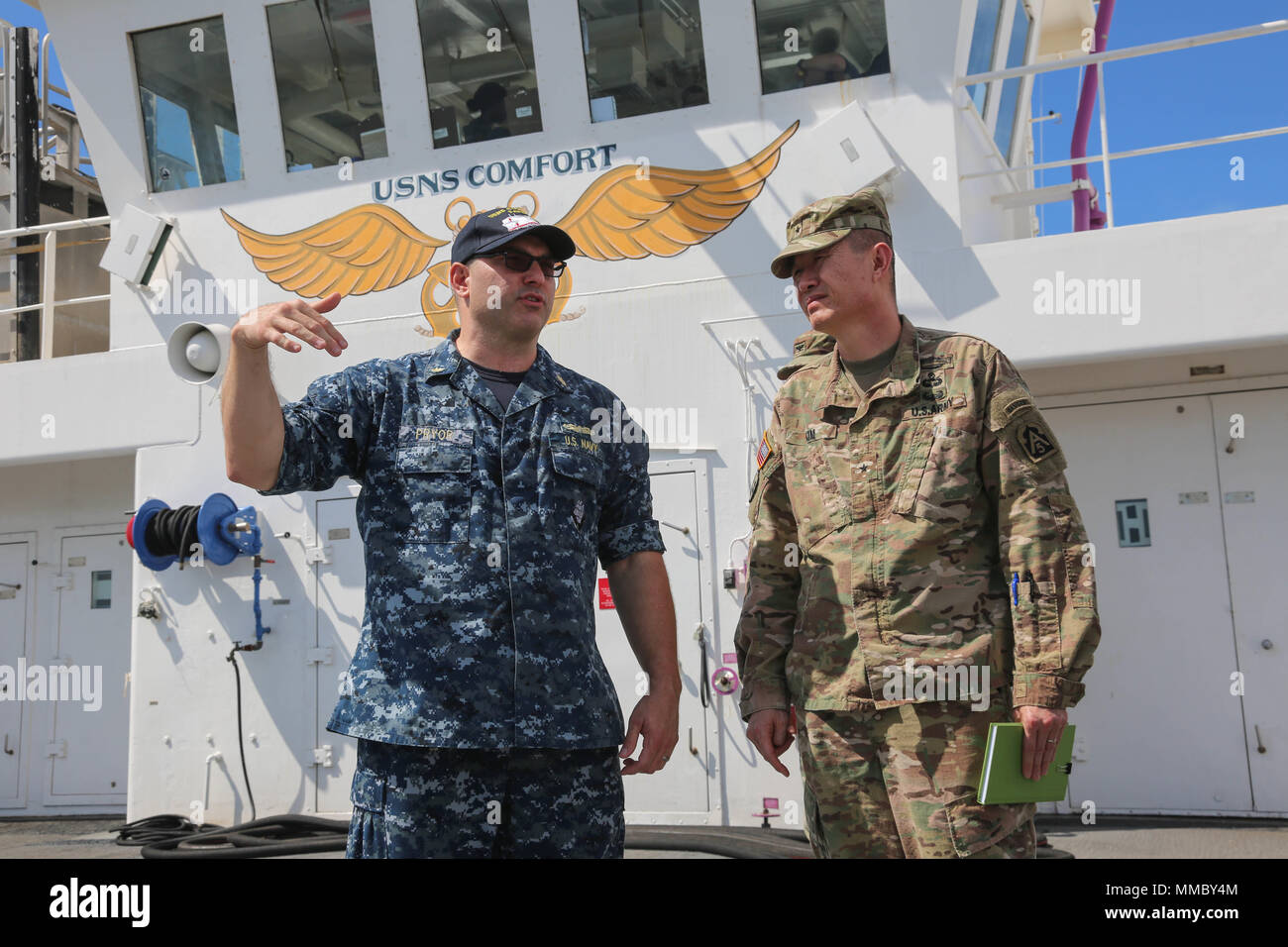 A U.S. Navy Sailor gives U.S. Army Brig. Gen. Richard C. Kim, Deputy Commanding General and Director of Operations, U.S. Army North (right), a tour of the Navy medical ship the USNS Comfort (T-AH 20), San Juan, Puerto Rico, Oct. 4, 2017. The USNS Comfort is a medical ship which is has been activated in order to accommodate the residents of Puerto Rico post Hurricane Maria. U.S. Army photo by Pfc. Caitlyn Cassidy) Stock Photo