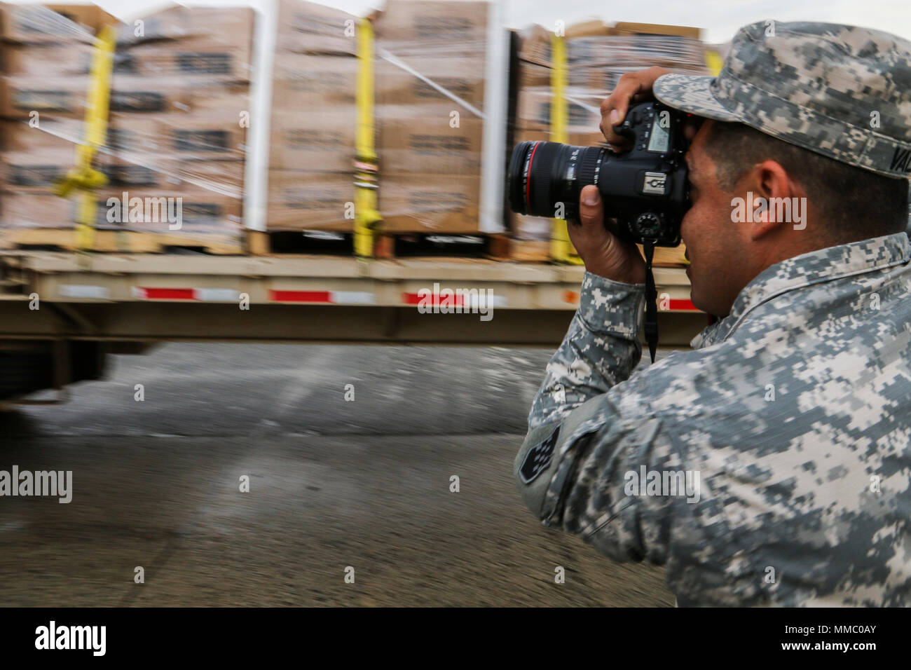 U.S. Army Reserve soldier, Sgt. Edgar Valdez, 220th Public Affairs Detachment, takes photos during a food delivery mission, that is part of Hurricane Maria relief efforts, outside of San Juan, Puerto Rico on Oct. 6, 2017. Valdez is part of a public affairs team that has spent the past several days working with Army Reserve soldiers, under the guidance and request of civil authorities, who are providing much needed supplies and resources to all of Puerto Rico. America’s Army Reserve can provide logistical, medical, and engineering support within hours of a disaster. Valdez is a public affairs p Stock Photo