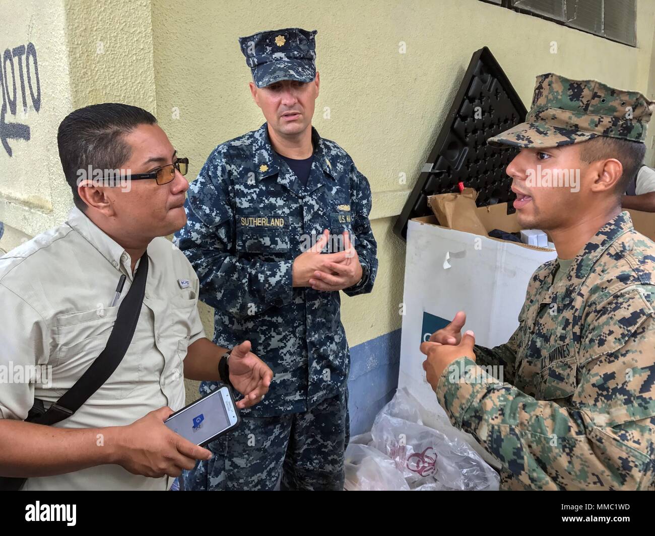 171006-A-QE286-0005 PUERTO BARRIOS, Guatemala (Oct. 6, 2017) Marine Lance Cpl. Rafael Tavera, right, assigned to 8th Engineer Support Battalion, translates for Lt. Cmdr. Ian Sutherland, technical director for Navy Entomology Center of Excellence, as he speaks to a local entomologist at Clinico Salud Del Puerto Barrios, a local health clinic, during Southern Partnership Station 17 (SPS 17). SPS 17 is a U.S. Navy deployment executed by U.S. Naval Forces Southern Command/U.S. 4th Fleet, focused on subject matter expert exchanges with partner nation militaries and security forces in Central and So Stock Photo