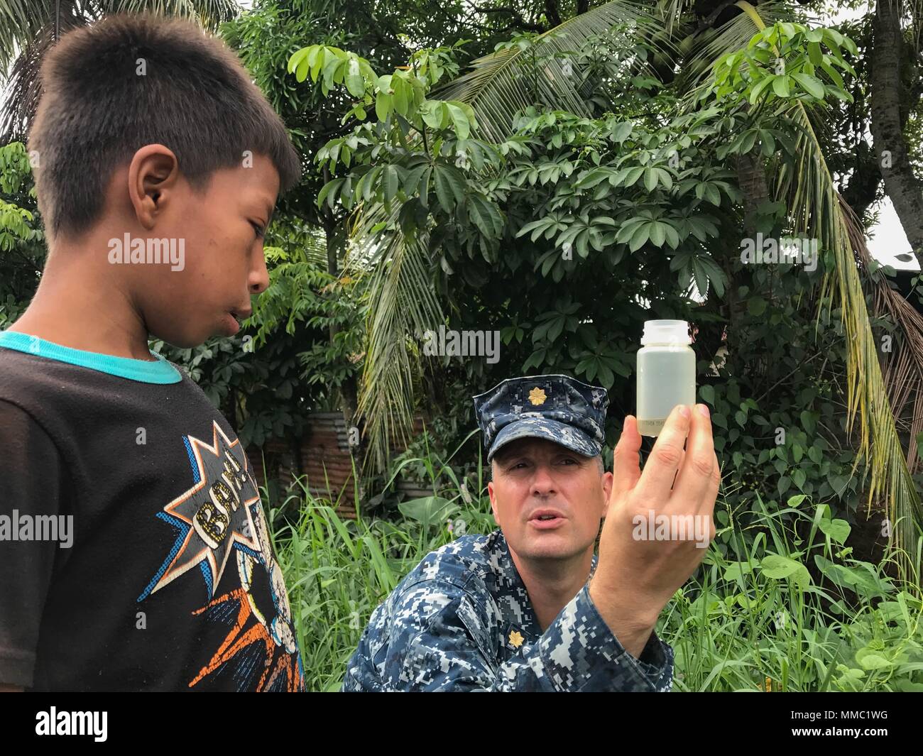 171006-A-QE286-0022 PUERTO BARRIOS, Guatemala (Oct. 6, 2017) Lt. Cmdr. Ian Sutherland, technical director for Navy Entomology Center of Excellence, shows a child mosquito larvae at Clinico Salud Del Puerto Barrios, a local health clinic, during Southern Partnership Station 17 (SPS 17). SPS 17 is a U.S. Navy deployment executed by U.S. Naval Forces Southern Command/U.S. 4th Fleet, focused on subject matter expert exchanges with partner nation militaries and security forces in Central and South America. (U.S. Army photo by SPC Judge Jones/Released) Stock Photo