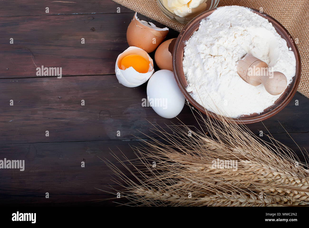 baking background with bake ingredients, ears, egg, flour and butter on