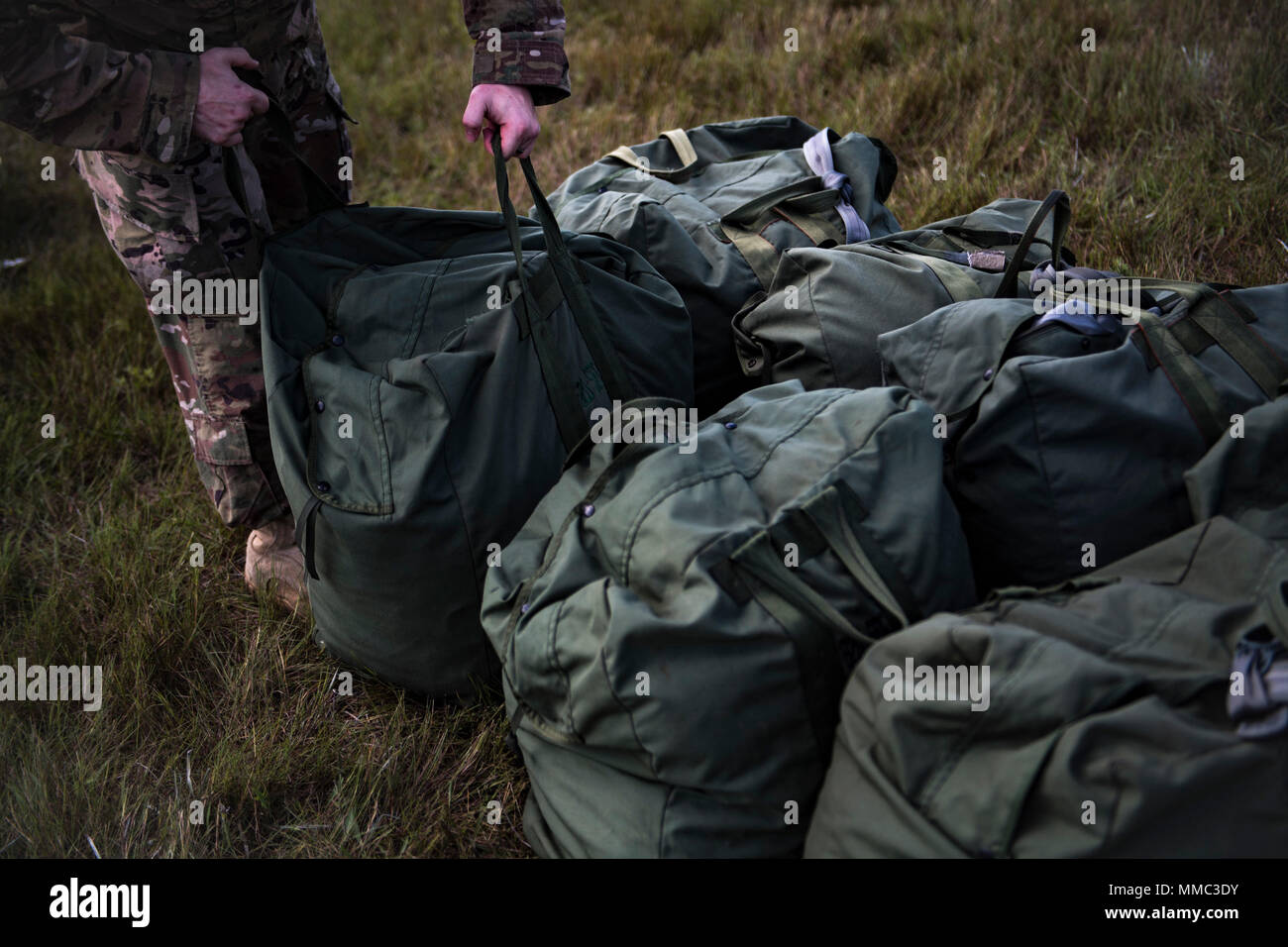 The archival image records airborne personnel organizing parachutes for ...