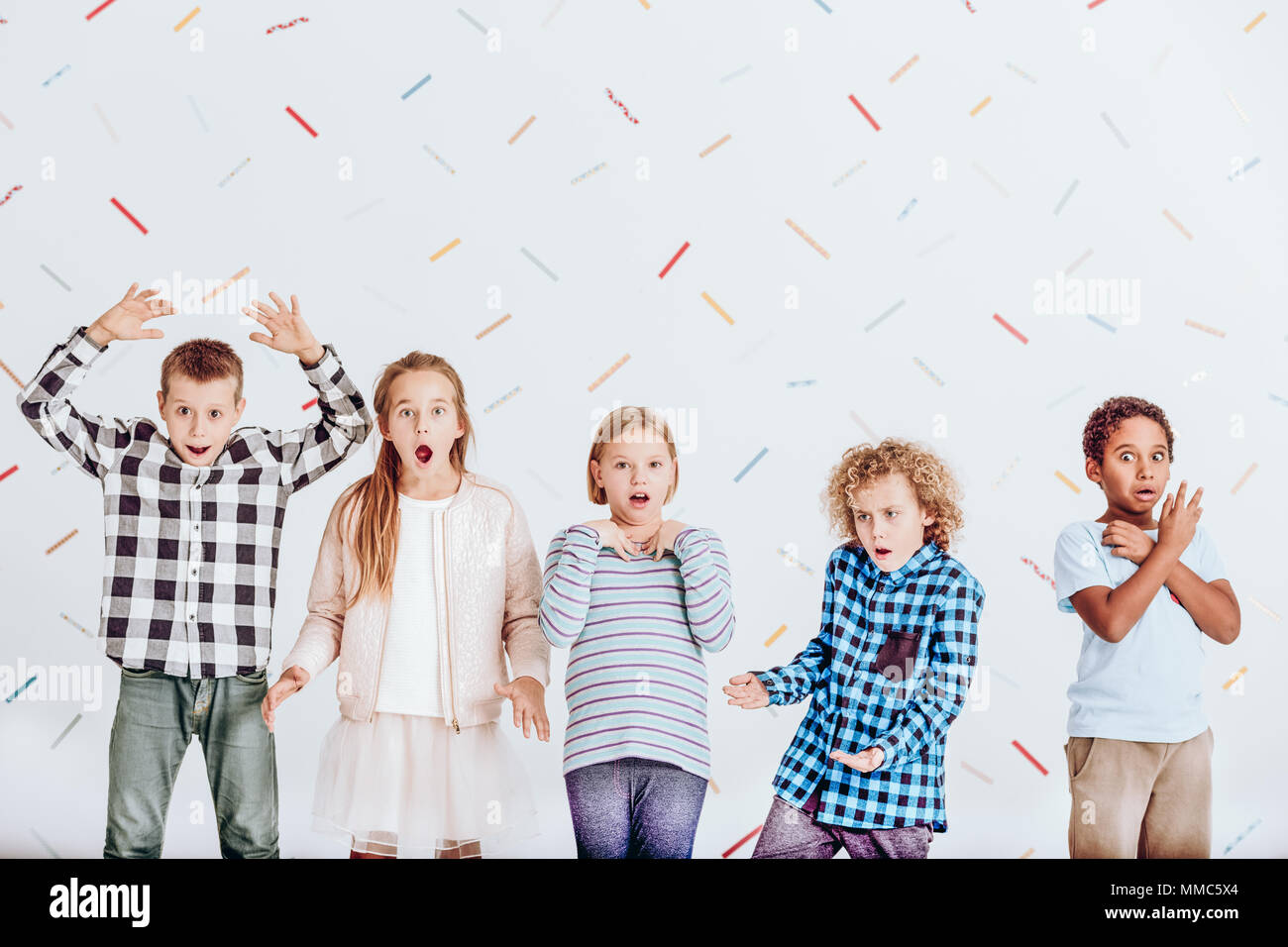Group of surprised kids standing in a room Stock Photo