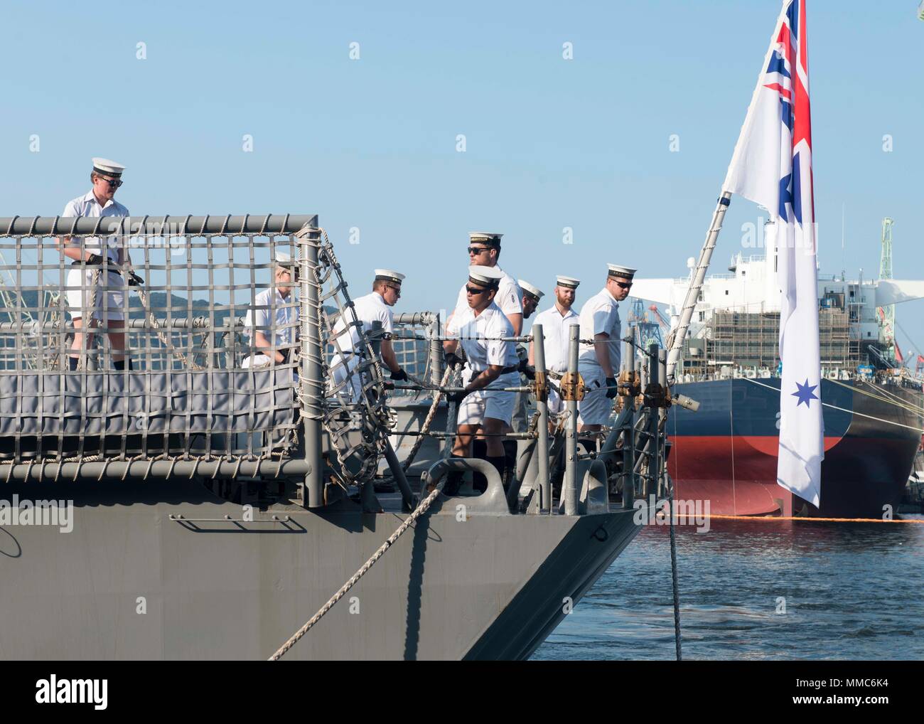171008-N-RY519-0043 SASEBO, Japan (Oct. 9, 2017) Sailors assigned to the Royal Australian Navy Adelaide-class guided-missile frigate HMAS Melbourne (FFG 05) pull in mooring line as the ship moors at U.S. Fleet Activities Sasebo for a routine port visit. (U.S. Navy photo by Mineman 3rd Class Zachary S. Horvath/Released) Stock Photo
