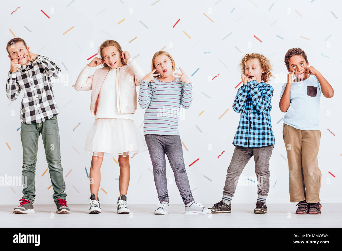Group of kids standing next to each other and pulling faces Stock Photo