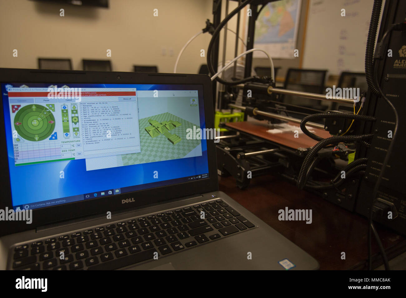 The 3-D printer from 2nd Battalion, 8th Marine Regiment is connected to a laptop with software and layouts needed to make pack clips at Camp Lejeune, N.C., Oct. 6, 2017. 2/8 is the first infantry battalion in the United States Marine Corps to utilize a 3-D printer to ensure battalion readiness in the event of equipment malfunctions. (U.S. Marine Corps photo by Lance Cpl. Ashley McLaughlin) Stock Photo