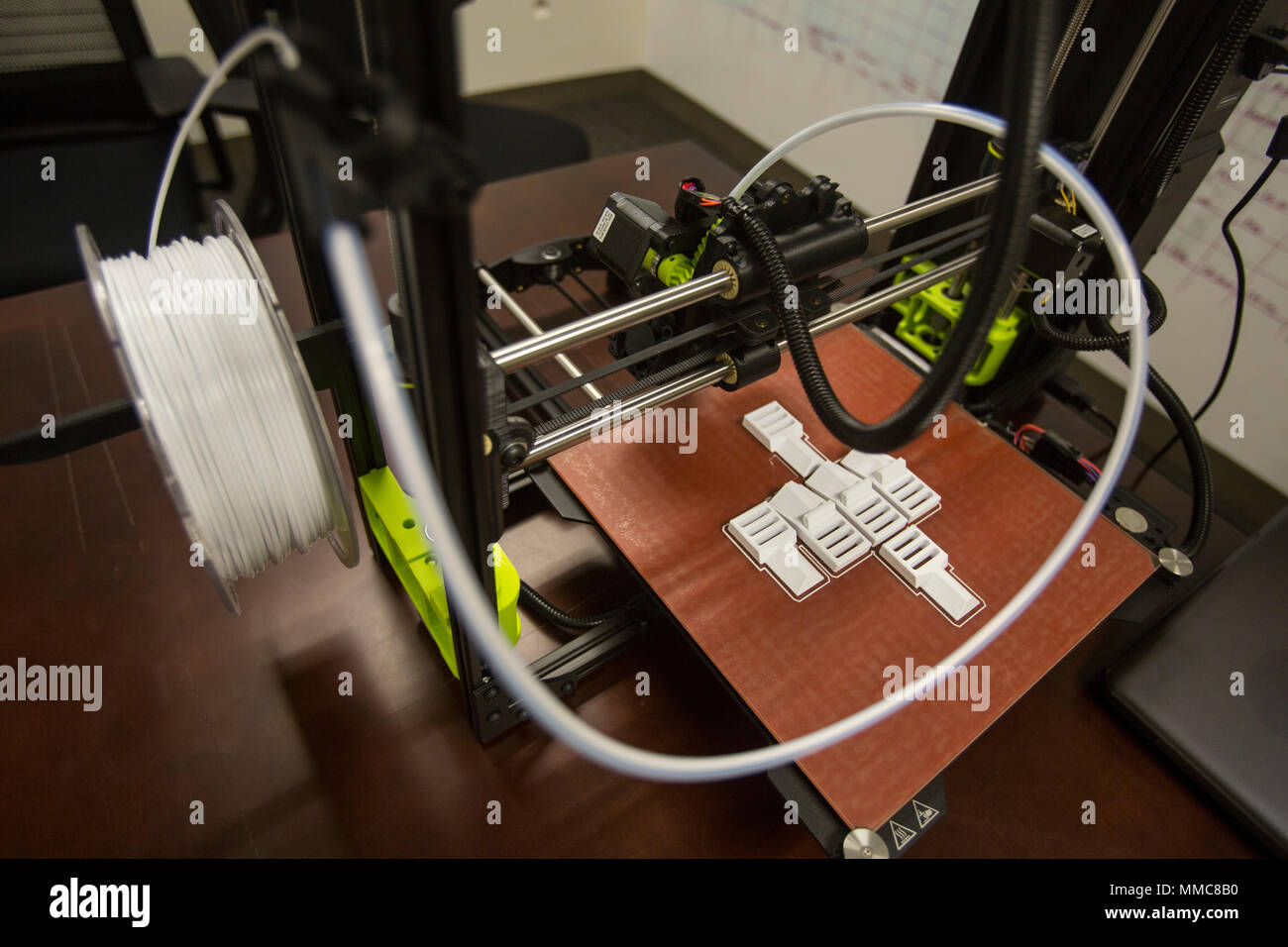 The 3-D printer and the finished layout of pack clips from 2nd Battalion, 8th Marine Regiment at Camp Lejeune, N.C., Oct. 6, 2017. 2/8 is the first infantry battalion in the United States Marine Corps to utilize a 3-D printer to ensure battalion readiness in the event of equipment malfunctions. (U.S. Marine Corps photo by Lance Cpl. Ashley McLaughlin) Stock Photo
