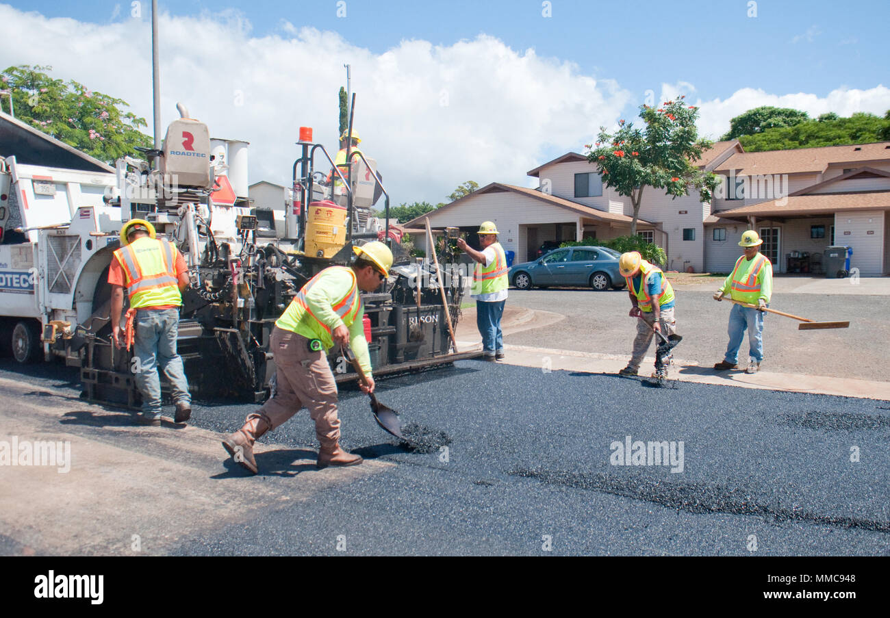 WHEELER ARMY AIRFIELD — Gilbert Torris (second from left), a laborer, and Wyatt Souza (second from right), a laborer, both with Grace Pacific LLC, shovel asphalt during the repaving of Lauhala Road near the Wili Wili neighborhood at Wheeler Army Airfield, Sept. 27, 2017. (U.S. Army photo by Kristen Wong, Oahu Publications) Stock Photo