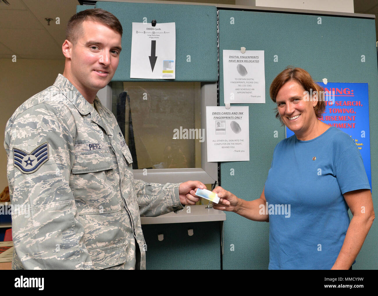 Staff Sgt. Andrew Pierce, 66th Security Forces Squadron Resource protection NCO in charge, issues a Defense Biometrics Identification System ID to Kimberly Elizabeth Carlson-Benner, a Gold Star family member, at Hanscom Air Force Base, Mass., Sept. 6. Issuing DBIDS ID cards to Gold Star family members is part of an Air Force initiative that allows unescorted access to Air Force installations to visit buried loved ones, attend base events and stop by the Airman and Family Readiness Center for immediate and long-term emotional support. Carlson-Benner, the daughter of U.S. Air Force Capt. John We Stock Photo