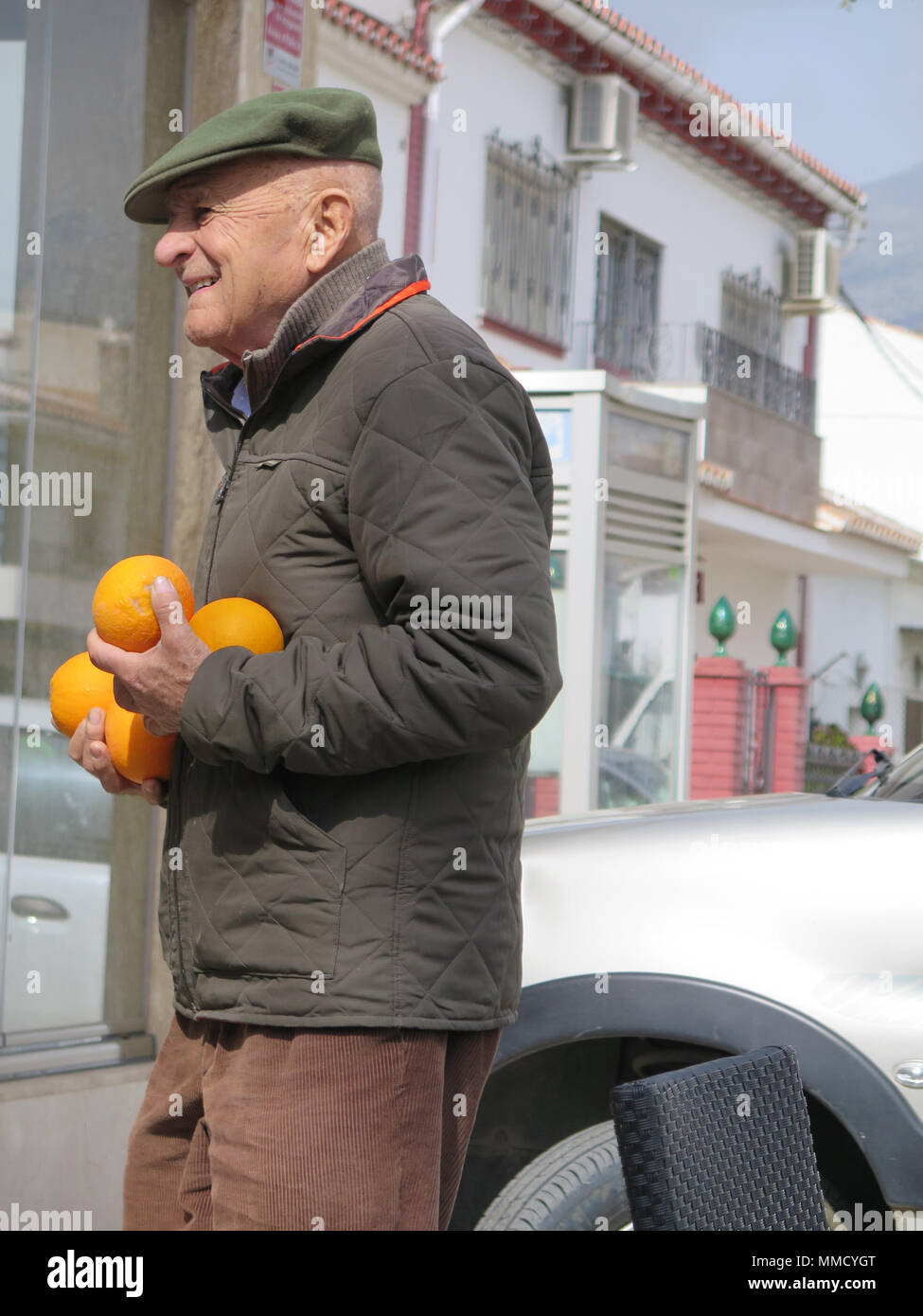 Alora, Spain - Febuary 24, 2017: Old man proudly carring his Orange crop in winter sunshine Stock Photo