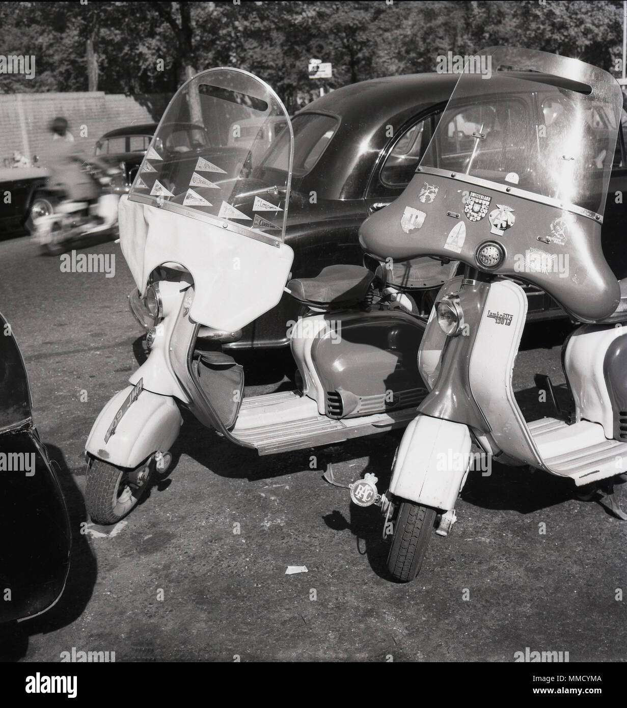 1960s, two scooters with fairings, Italian-made Lambrettas, parked in a street in London, England, UK. The Lambretta 1501d has both RAC and AA badges and stickers on the fairing, suggesting it has been well used for overseas touring. Stock Photo