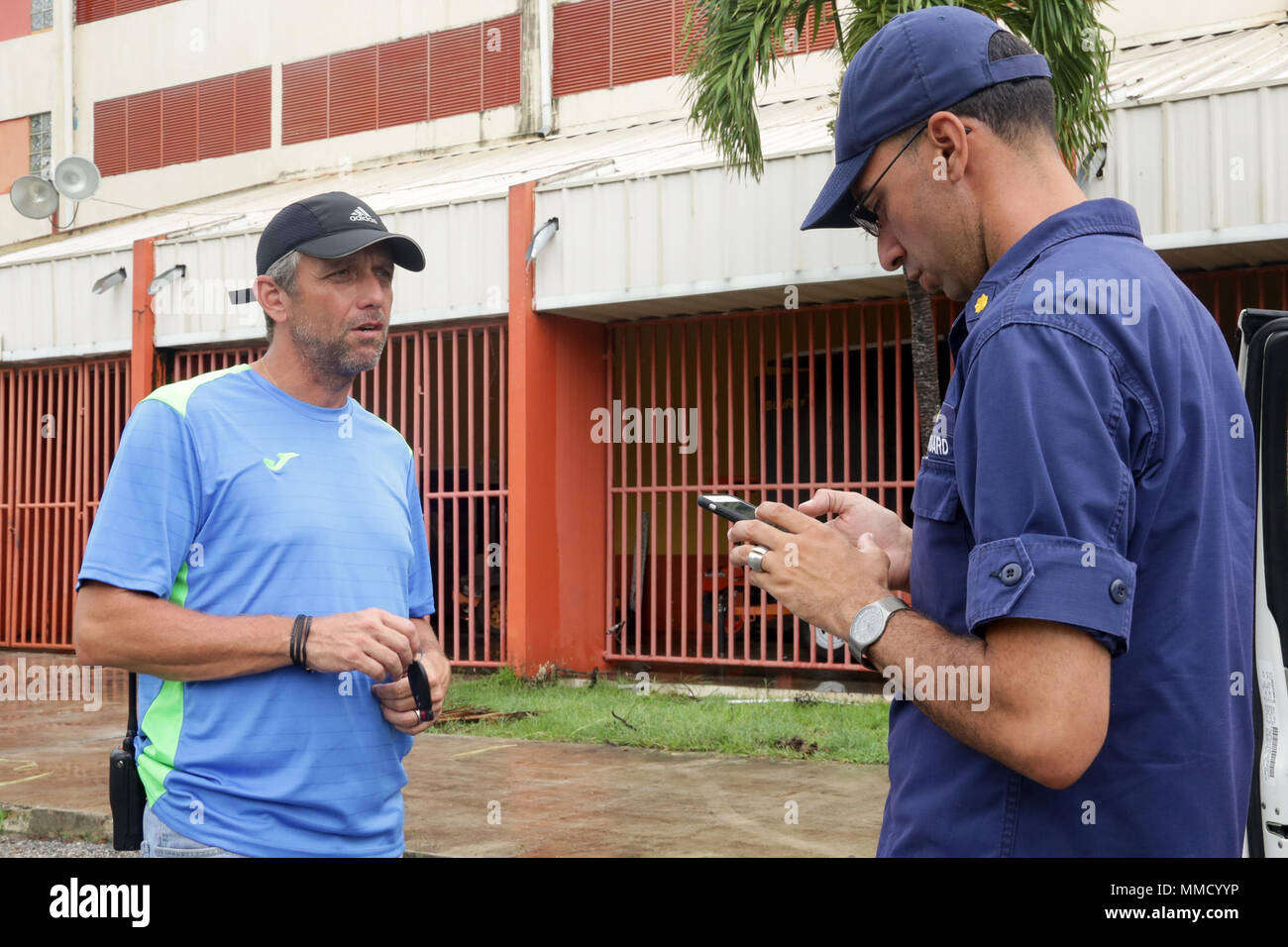 U.S. Coast Guard Lt. Cdr. Jose M. Roasario Carpio (right), FEMA Intergovernmental, Affairs Division 9 Supervisor, speaks with the Mayor of Coamo Juan Carlos Garcia Padilla on how he can help with the city in Coamo, Puerto Rico, Oct. 16, 2017. Rosario was sent by FEMA to make sure grocery stores throughout the city were stocked, and the locals are receiving basic needs from the Mayor. (U.S. Army photo by Pfc. Kyara Aguilar) Stock Photo