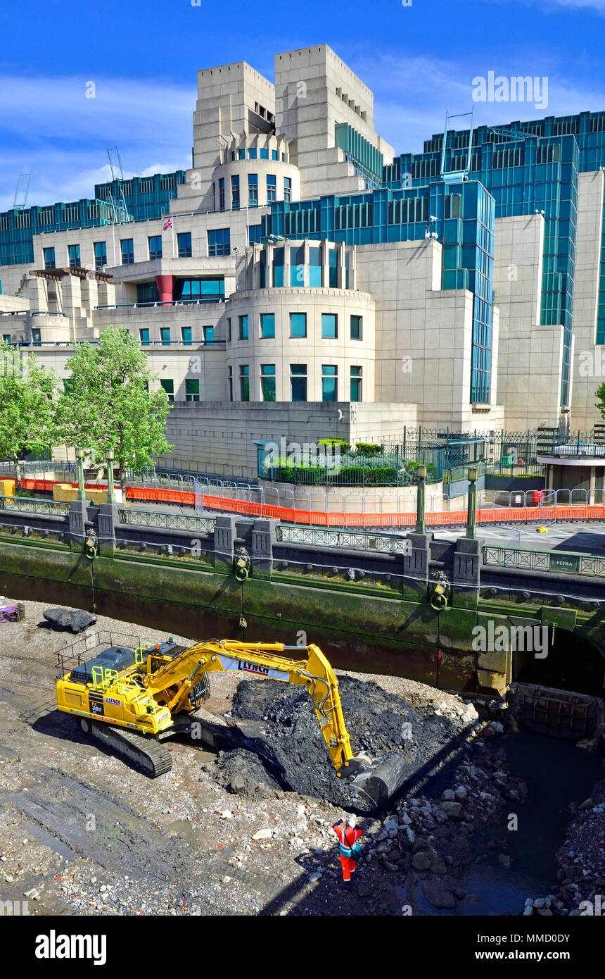 London,England, UK. SIS Building / MI6 headquarters at Vauxhall Cross. Excavator digging on the beach below at low tide Stock Photo