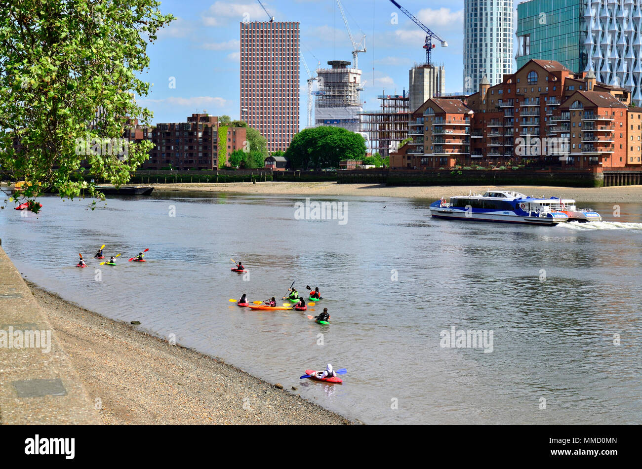 London,England, UK. Children canoeing on the river Thames, opposite Battersea Power Station Stock Photo