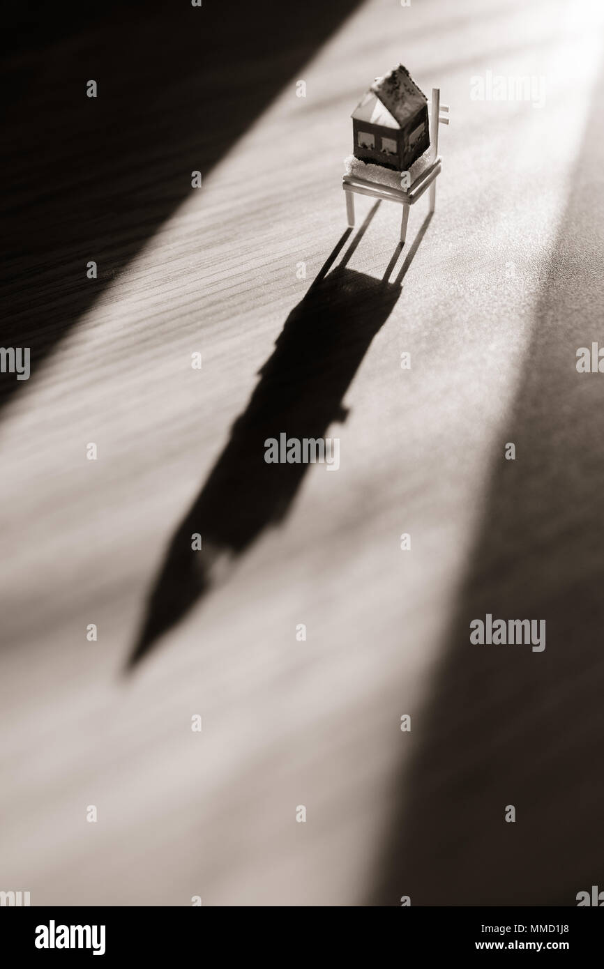 Little toy house standing on a chair Stock Photo