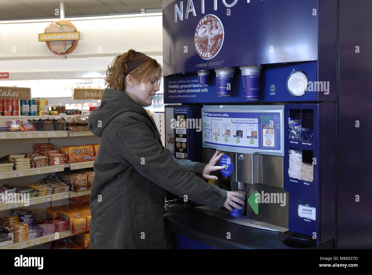 Woman buying coffee from a vending machine Stock Photo Alamy