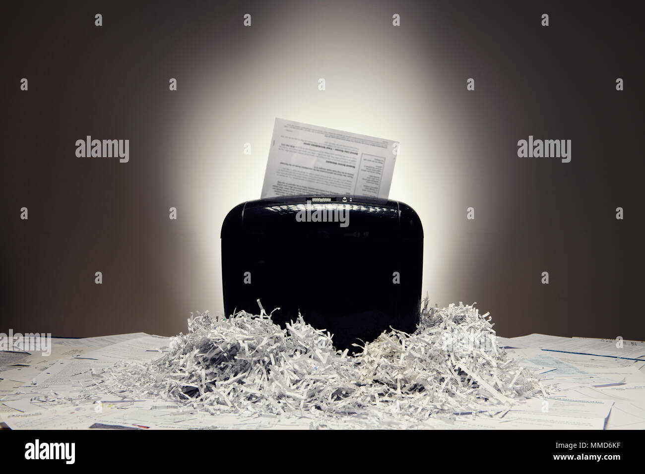 Office shredder and personal documents being shredded, with piles of