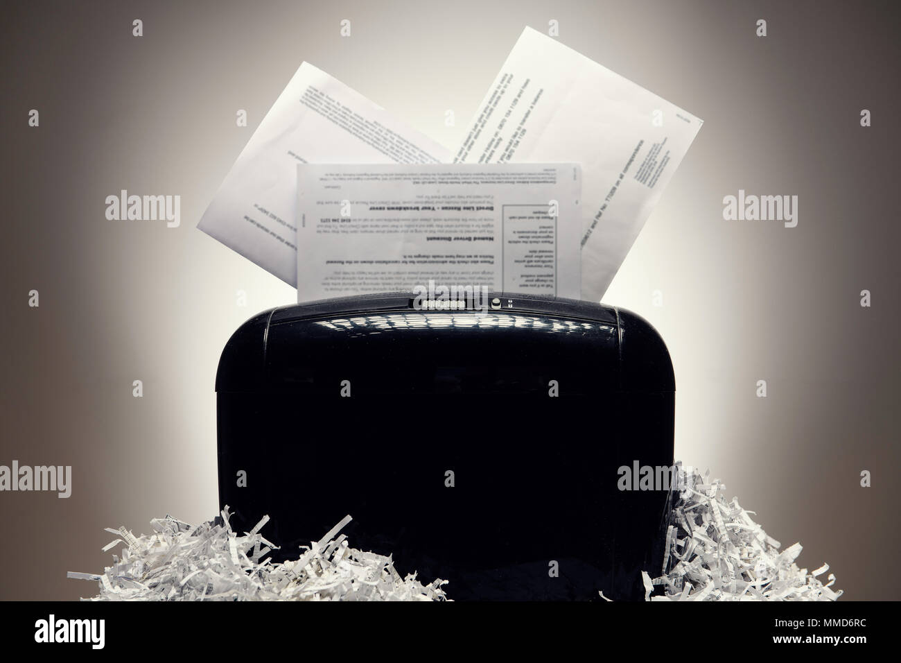 Office shredder and personal documents being shredded, with piles of