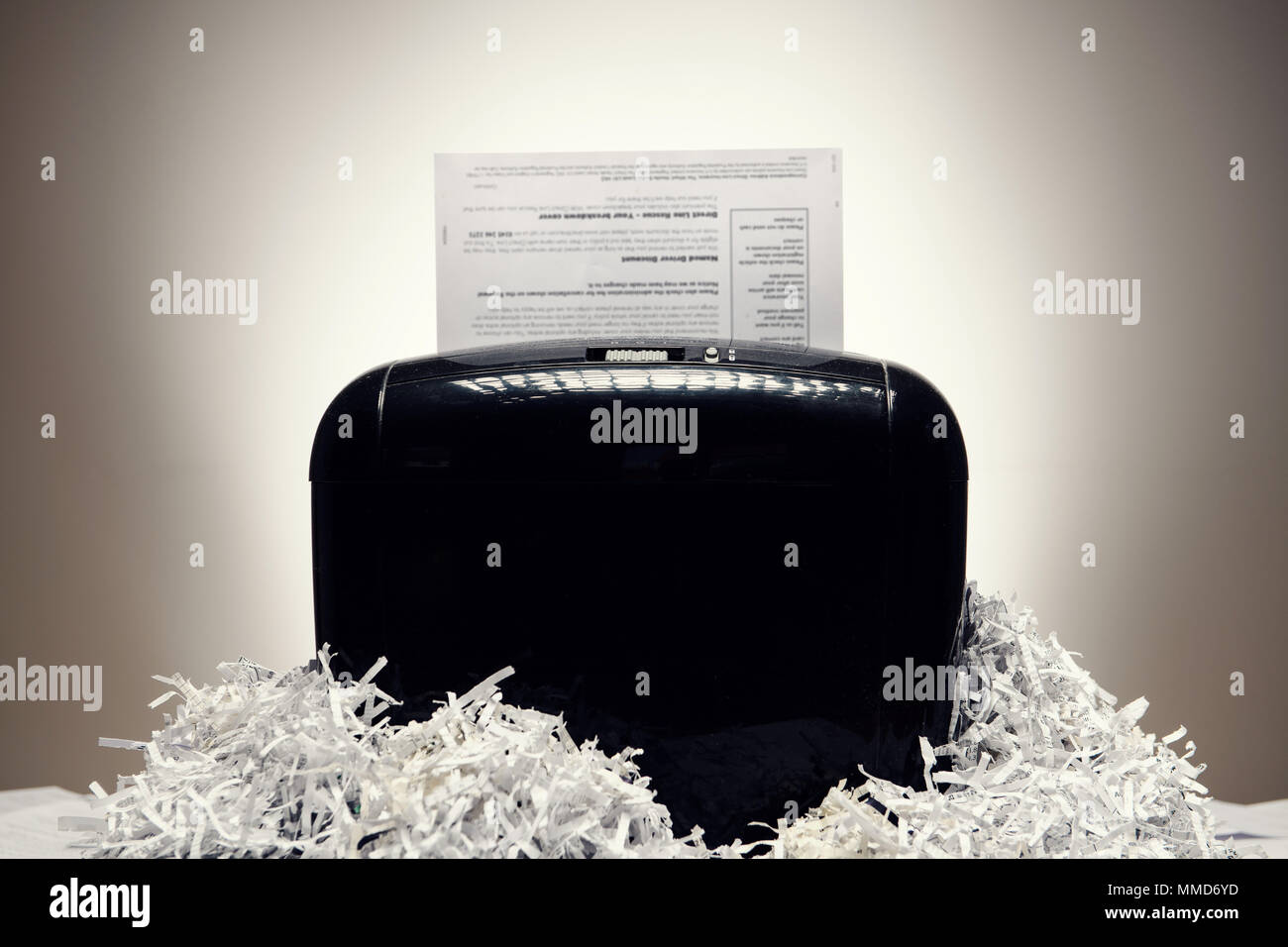 Office shredder and personal documents being shredded, surrounded by