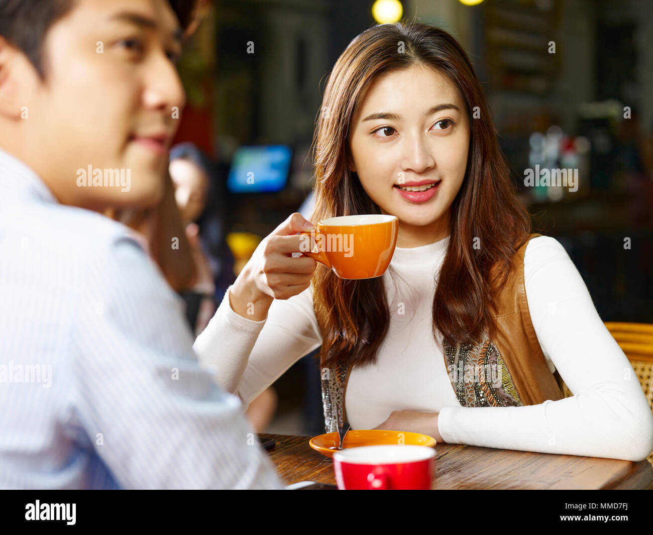 happy young asian couple lovers sitting at table in coffee shop. Stock Photo