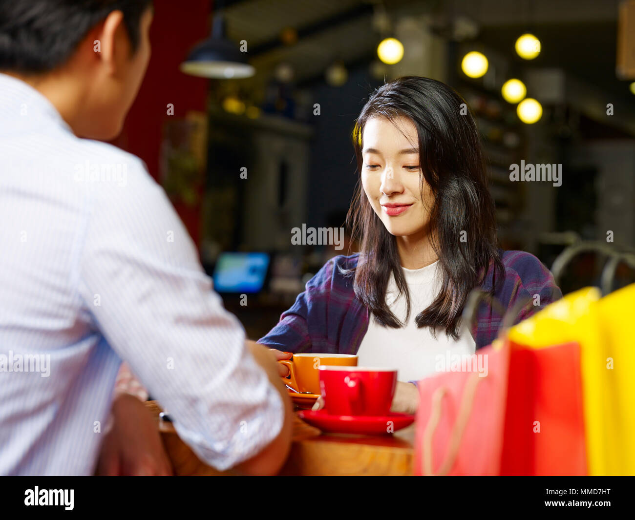 young asian couple lovers sitting at table chatting talking in coffee shop after shopping. Stock Photo