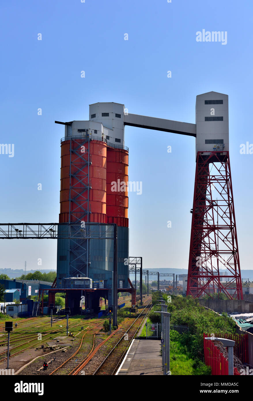 Two bulk handling silos with conveyor belt houses on top, used to discharge coal for power station to moving trains below, Avonmouth, Bristol, UK.  Th Stock Photo