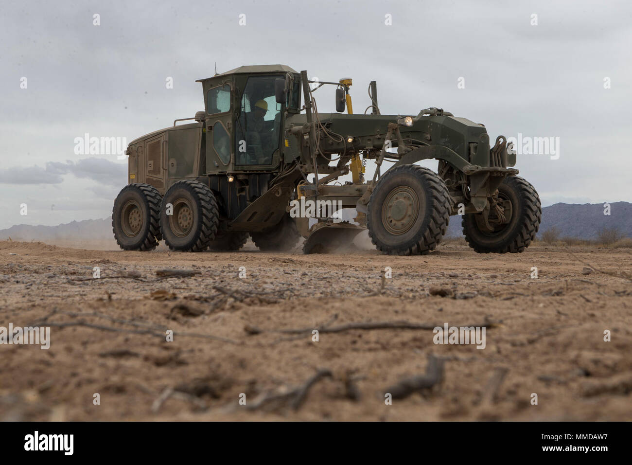 U.S. Marine Corps Pfc. Myles Bautista, a heavy equipment operator with Marine Wing Support Squadron 272, operates a 120m road grader during airfield maintenance in support of Weapons and Tactics Instructor course (WTI) 2-18 at STOVAL Expeditionary Airfield, Dateland, Ariz., March 16, 2018. WTI is a seven-week training event hosted by Marine Aviation Weapons and Tactics Squadron One (MAWTS-1) cadre, which emphasizes operational integration of the six functions of Marine Corps aviation in support of a Marine Air Ground Task Force and provides standardized advanced tactical training and certifica Stock Photo