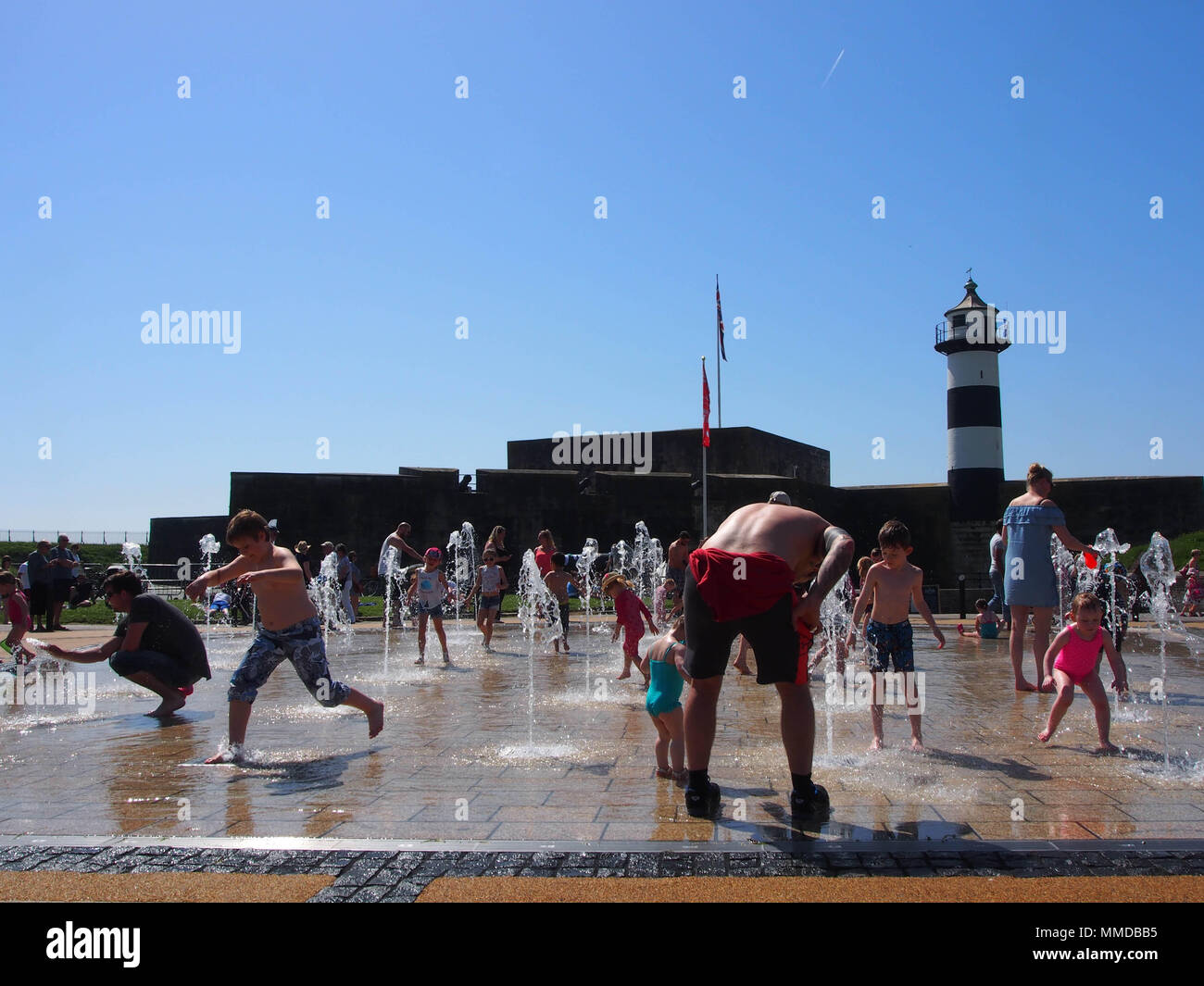 Families play at the water feature outside Southsea castle in Portsmouth, England Stock Photo