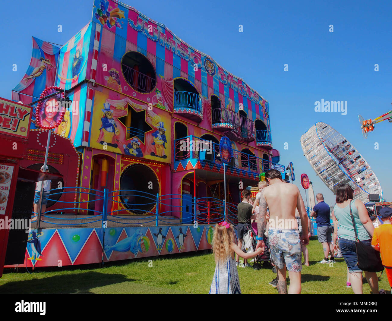 Families walk through a fairground on a summers day Stock Photo