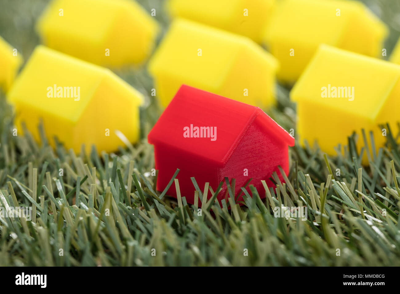 Close-up Of A Red House Model On Green Grass Stock Photo