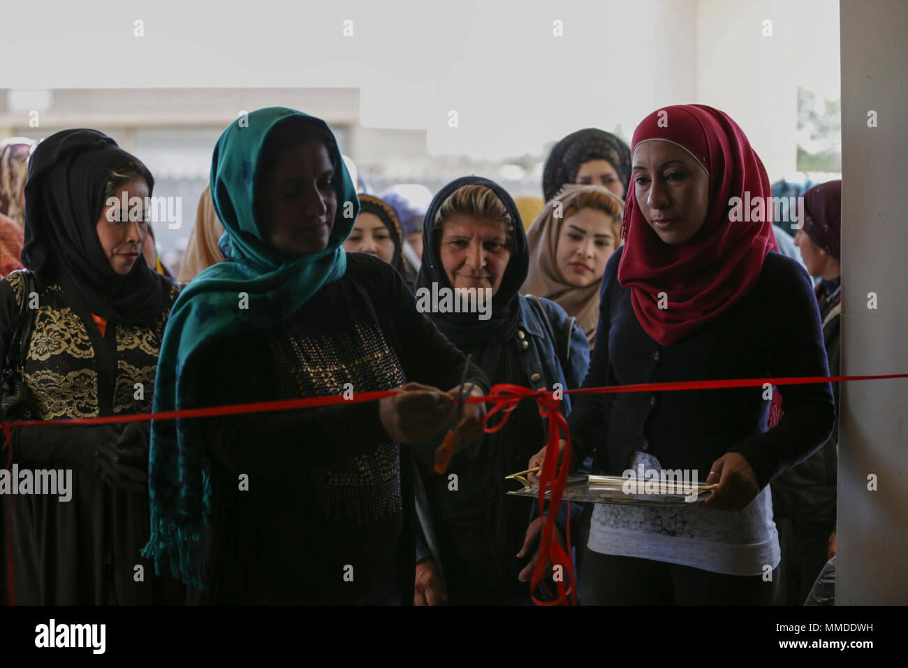 Raqqah Civil Council’s women’s committee co-president, Fairuz, cuts the ribbon declaring the opening of the new women’s center in Khatuniyah, Syria, March 26, 2018. Coalition Forces are supporting the Raqqah Civil Council’s objective to restore critical infrastructure and services in Raqqah and the surrounding area.  (U.S. Army Stock Photo