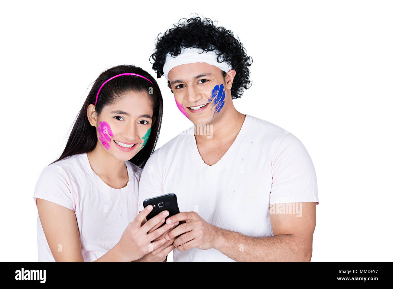 Smiling Two Teenage Couple Holi Festival Sending Text-Message On Cell-Phone Stock Photo